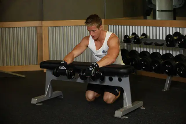 Palms-Down Dumbbell Wrist Curl Over A Bench 1
