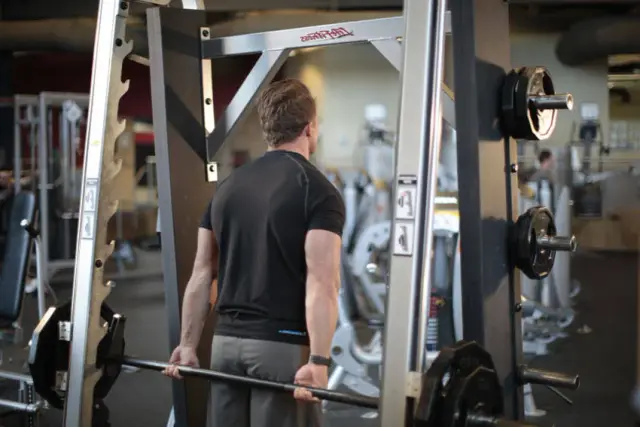 Smith Machine Behind the Back Shrug — Start